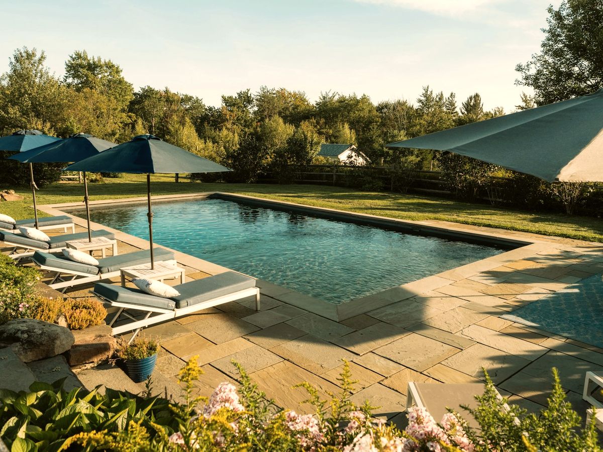 Stone patio, pool surround and retaining wall with manicured lawn